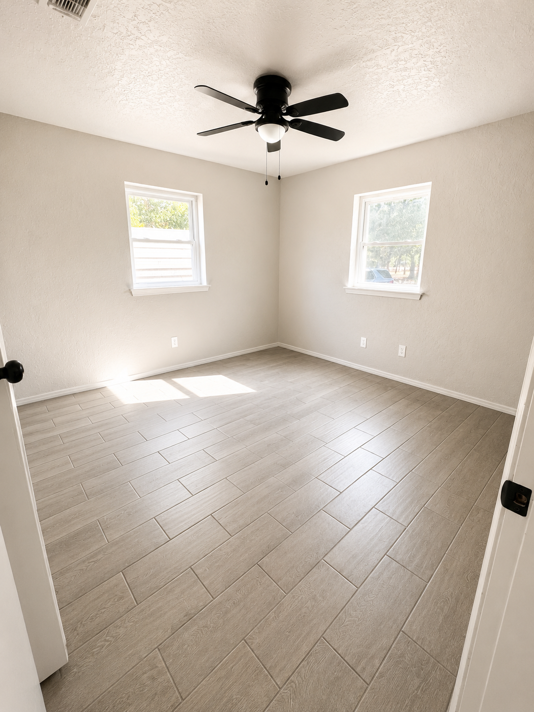Bedroom with two windows and ceiling fan