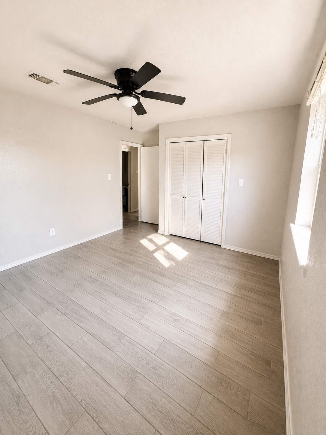 Bedroom with closet, window and ceiling fan
