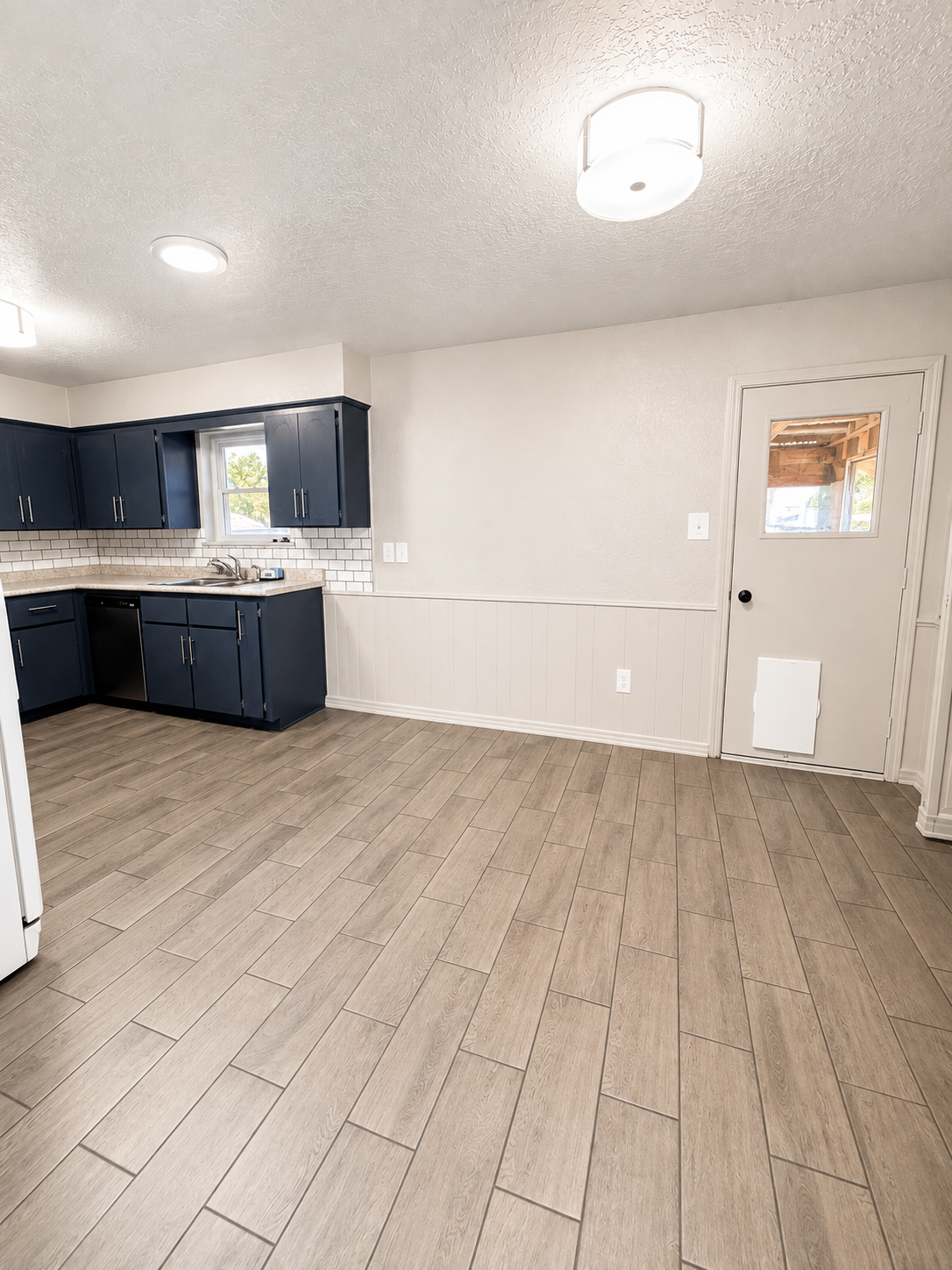 Kitchen and dining area with wood-look tile flooring
