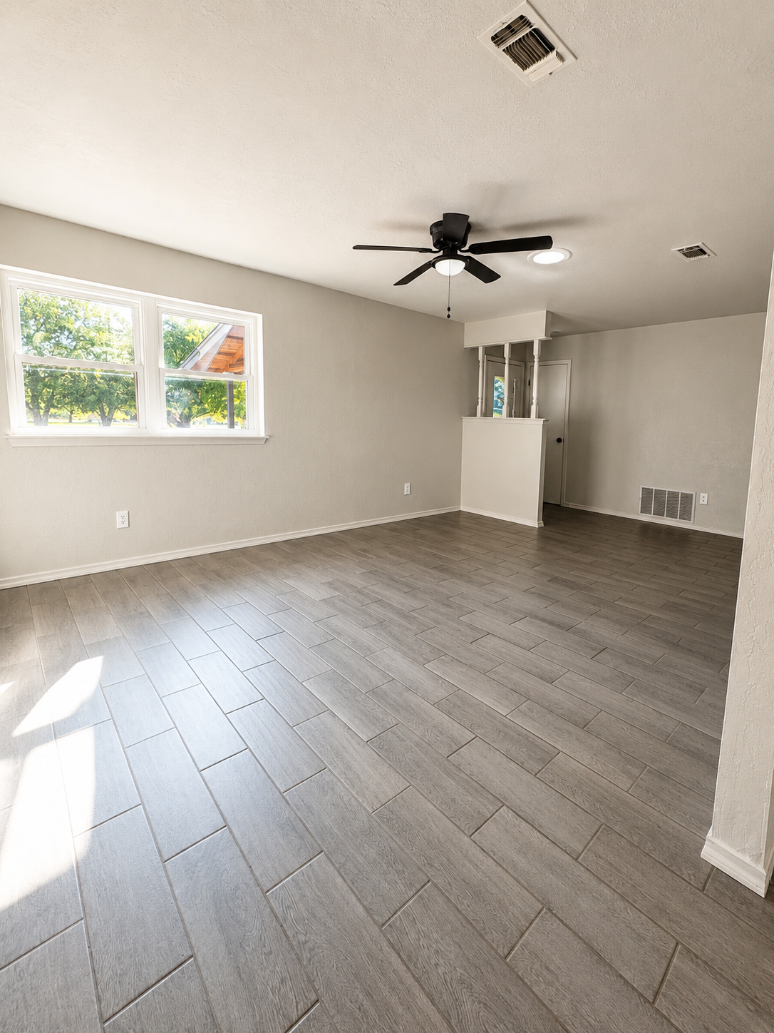 Living room with windows and wood-look tile flooring